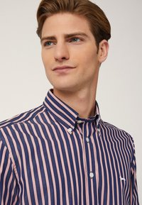 Camicia con bottoni, a righe verticali blu e rosa, realizzata in cotone. Presenta un colletto e un piccolo logo ricamato sul petto.