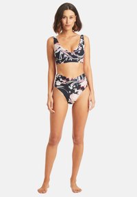Set bikini floreale con uno sfondo blu navy scuro, caratterizzato da un top bralette incrociato e un fondo a vita alta. Il materiale sembra liscio e elastico.
