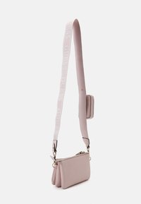 Rosa kunstlæder håndtaske med tekstureret overflade, udstyret med en logo-rem og en lynlåslomme. Accentueret med guldfarvet hardware og sort kant.