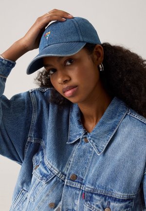 Cappellino da baseball in denim con visiera curva, di colore azzurro chiaro, con ricamo triangolare multicolore sul frontale.