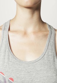 Grijze tanktop met een ronde halslijn en dunne bandjes, gemaakt van zachte, lichtgewicht stof met een subtiele textuur.