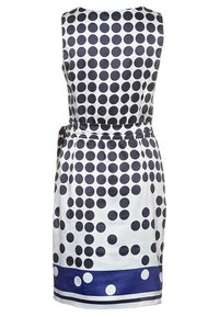 Robe sans manches en satin blanc avec de grands pois navy, taille ceinturée et une bande horizontale navy contrastante à l'ourlet.