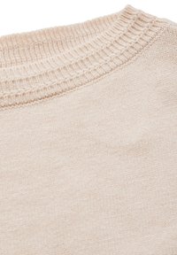 Ljusbeige tröja i närbild med en strukturerad ribbad halsringning och mjukt, slätt tyg. Designen är enkel utan mönster eller accenter.