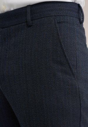 Donkerblauwe broeken met een visgraatpatroon en een gladde textuur; heeft een getailleerde pasvorm en een subtiele glans. Inclusief zijzakken en riemlussen.