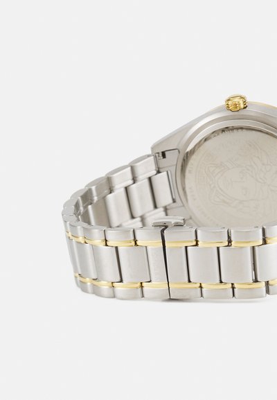 Silver stainless steel watch with gold accents on the band, featuring a textured case back and a detailed crown.