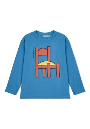 Long-sleeve, blue cotton T-shirt featuring a graphic of a chair in orange and black, with a yellow circular accent behind it.
