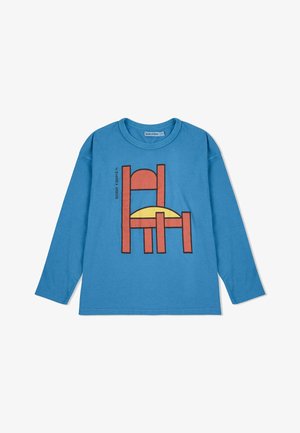 Blauwe katoenen T-shirt met lange mouwen, voorzien van een grafisch ontwerp van een stoel in oranje en zwart, met een gele cirkelvormige accent erachter.