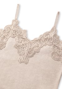 Nude tanktop met delicate kantafwerking langs de halslijn en verstelbare spaghettibandjes. Zachte textuur met een gladde afwerking.