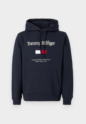 Marineblauer Hoodie mit Fronttasche, Kordelzugkapuze, dem Schriftzug „Tommy Hilfiger“, rot-weiß-blauem Logo und dem Aufdruck „Established MCMLXXXV New York City“.