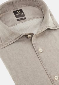 Camicia di lino beige con vestibilità regolare, dotata di colletto classico, due bottoni sulla patta e un'etichetta nera con "Boggi Milano."