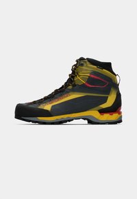 Bota de caminhada de cano alto com um esquema de cores preto e amarelo, tecido em malha, sola de borracha e calcanhar reforçado. Inclui atacadores integrados e detalhes.