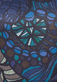 Tissu à motifs avec un fond sombre et des couleurs vives : sarcelle, bleu et marron, présentant des formes abstraites et des textures.