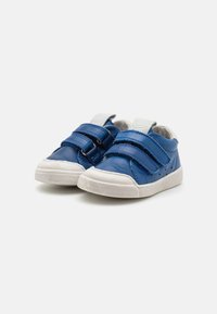Pantofi din piele albastră cu talpă din cauciuc alb, dotati cu două curele velcro și interior moale pentru confort. Vârful rotunjit și designul casual.