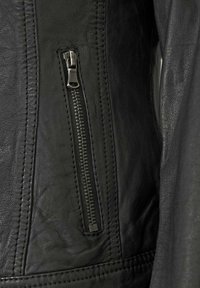 Schwarze Lederjacke mit strukturiertem Finish. Verfügt über eine seitliche Reißverschlusstasche und auffällige Nähte entlang der Nähte.