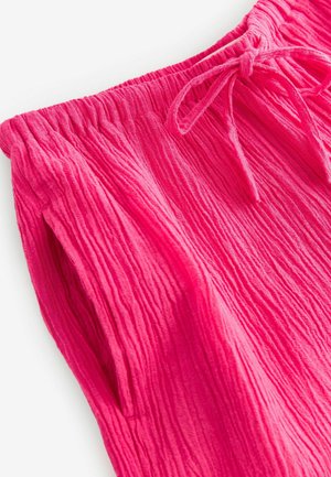 Helles Pink, strukturierter Stoff mit einem gerafften Design. Verfügt über einen elastischen Bund mit Kordelzug und seitlichen Taschen.
