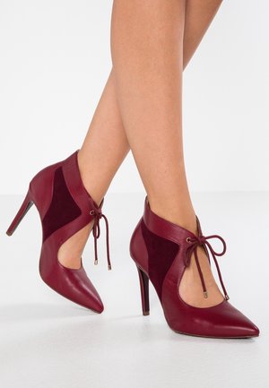 Bordowe botki na wysokim obcasie za kostkę z panelami ze skóry i zamszu, w szpic, z możliwością sznurowania, o gładkiej fakturze i eleganckim kształcie.