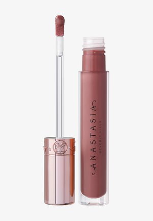 Flüssiger Lippenstift in einem transparenten, zylindrischen Behälter mit roségoldenem Deckel. Weicher Applikator mit abgerundeter Spitze. Farbton erscheint mauve.