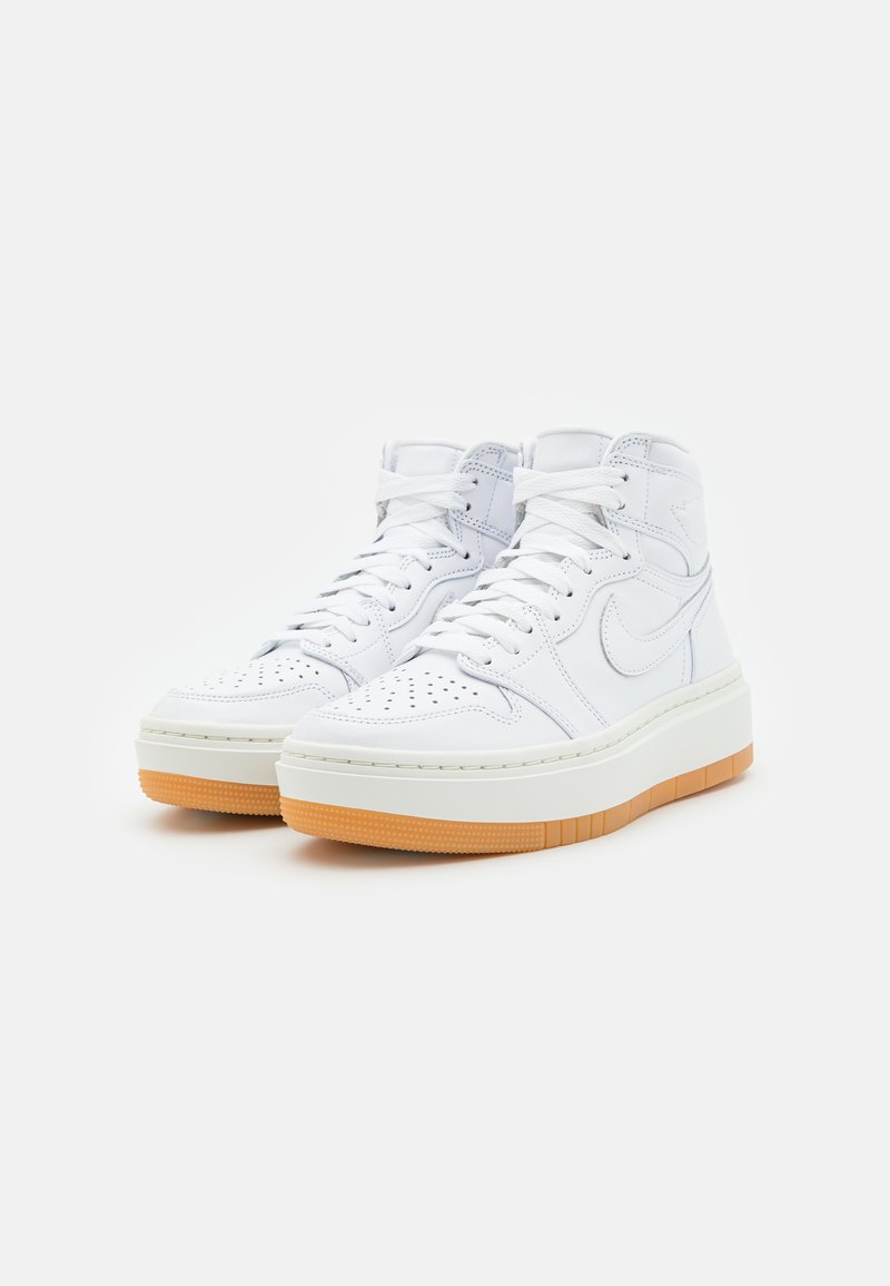 Weiße Leder-Hochtop-Sneaker mit perforiertem Zehenbereich, weißen Schnürsenkeln und dicker Gummisohle. Ikonisches Swoosh-Logo an der Seite.