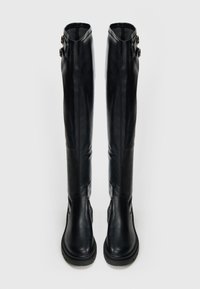 Μαύρες δερμάτινες μπότες μέχρι το γόνατο με ομαλή υφή, διαθέτουν δύο διακοσμητικές αγκράφες στο πλάι και χοντρή σόλα για επιπλέον σταθερότητα.