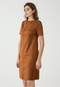 Braunes Kleid aus Kunstsuede mit kurzen Ärmeln, das ein schlichtes Design, einen runden Halsausschnitt, dezente Steppdetails und eine gerade Silhouette bietet.