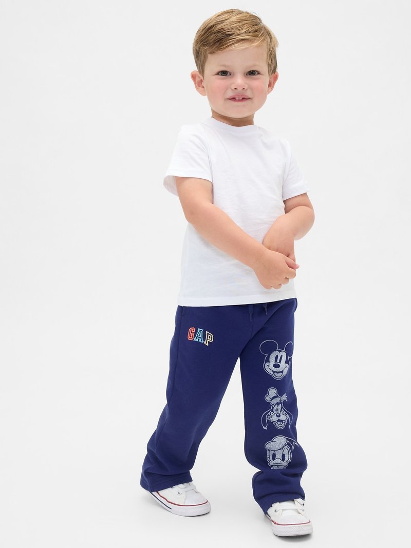 Pantalones de chándal en color navy con cinturilla elástica, logo "GAP" en multicolor y personajes de Disney impresos: Mickey Mouse, Donald Duck y otros.