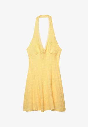 Žluté halter šaty s texturovanou látkou. Hluboký výstřih do V, přiléhavý korzet a rozšířená sukně. Vlnkované okraje na výstřihu.