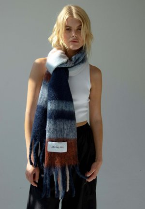 Écharpe en mélange de laine présentant des dégradés de bleu marine, gris et rouille, avec des bords frangés et une étiquette "ARCTIC FOX" pour le détail de la marque.