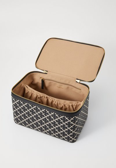 Rektangulär kosmetikväska med ett svart och kr�ämfärgat geometriskt mönster. Dragkedjans stängning avslöjar ett beige inre med en rynkad ficka och en liten dragkedjeficka.