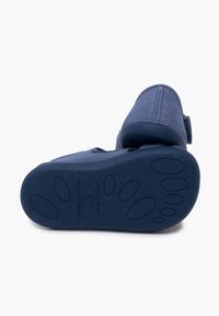 Modrá textilní bota s texturovanou podrážkou, kulatou špičkou a nastavitelným páskem. Na podrážce se nachází reliéfní design tlapky.