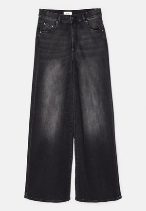 Jeans évasés taille haute en denim gris foncé. Présentent une finition délavée, deux poches avant et des accents métalliques près des poches.