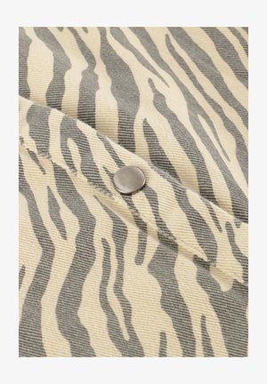 Tkanina w zebra wzór w beżowych i szarych odcieniach, z detalem w postaci srebrnego zatrzasku na textured powierzchni.