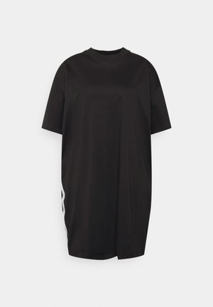 Mustat ylisuurent toimintapaidan, joka on valmistettu sileästä puuvillasta. Siinä on pyöreä kaula-aukko, lyhyet hihat ja sivureikä, jossa on kontrastivärinen valkoinen reunus.