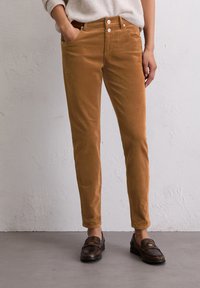 Bruine corduroy broek met een slim fit, voorzien van twee voorzakken, een klassieke knoopsluiting en een textuurstof voor extra warmte.