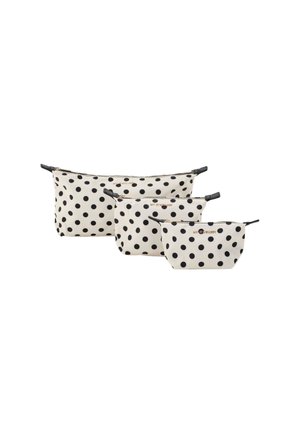 Drie stippenpouches in crème met zwarte stippen, gemaakt van stof met ritsen en zwarte accenten, variërend in grootte.