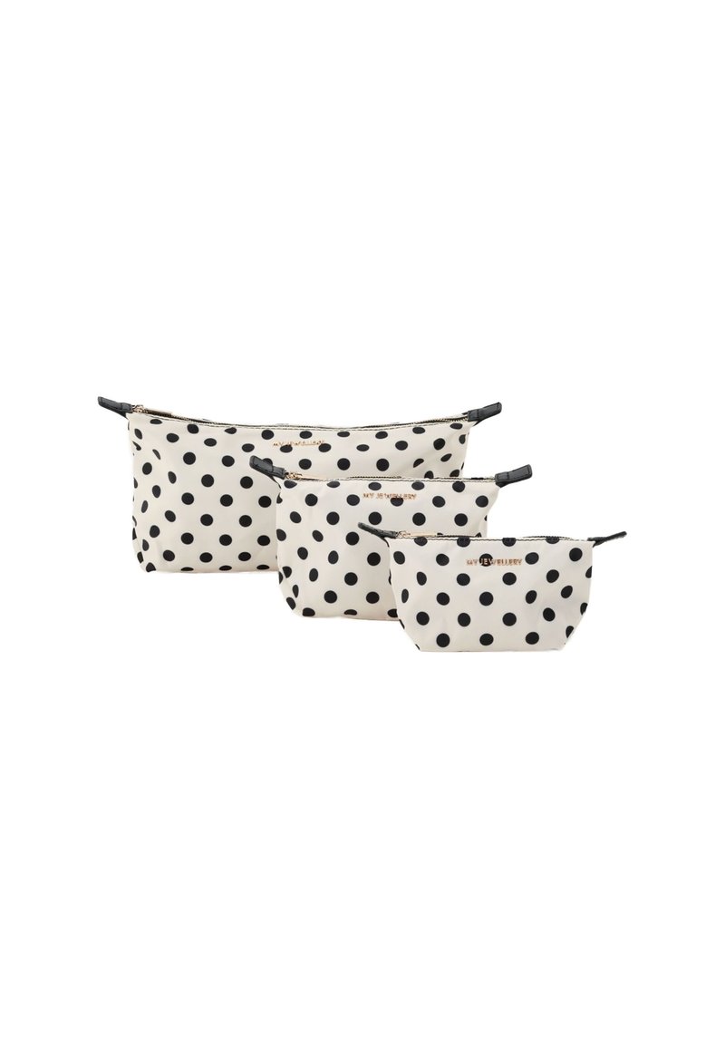 Trois pochettes à pois crème avec des pois noirs, fabriquées en tissu avec des fermetures éclair et des accents noirs, de tailles variées.
