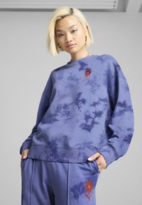 Felpa tie-dye viola con ricamo di un fiore rosso, vestibilità comoda, polsini e orlo a costine, abbinata a pantaloni coordinati.