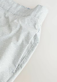 Blue and white patterned fabric with geometric design, soft texture, showing a folded section and visible stitching details.