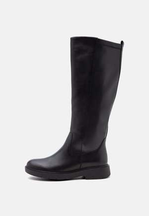 Botas altas negras de cuero con suela plana y puntera redondeada, acabado liso y detalles de costura sutiles sobre fondo blanco.