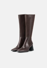 Brown leather knee-high boots with a smooth finish, pointed toe, and a block heel. Features a zipper on the inner side for easy wear.