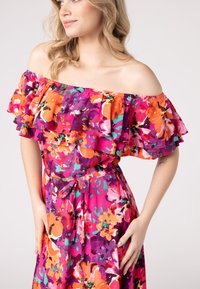 Abito floreale off-the-shoulder con volants a strati, in vivaci colori rosa, arancio e viola, con una vita con cintura e una trama di tessuto morbido.