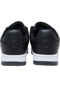 Sorte lær sneakers med en glat overflade, polstret krave og hvid gummisål. Bagfra ses kontrasterende teksturer og et strømlinet design.