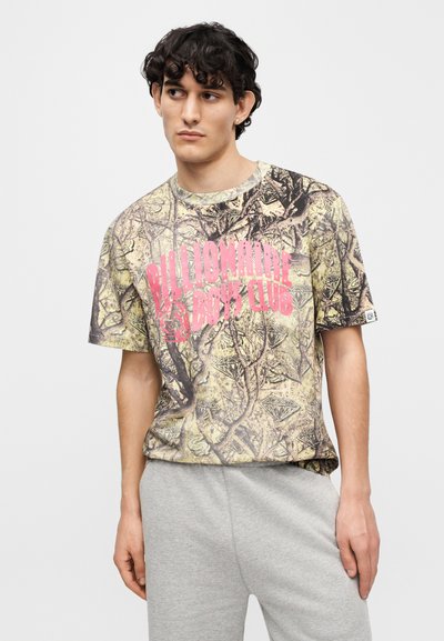 Μπλουζάκι σε μπεζ και πράσινο καμουφλάζ με ροζ λογότυπο "Billionaire Boys Club"· κοντά μανίκια, στρογγυλή λαιμόκοψη, βαμβακερό ύφασμα.