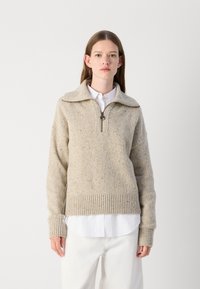Sweater bege de malha com colarinho de meio zíper, punhos e bainha canelados, apresentando uma superfície texturizada com discretas manchas de várias cores.
