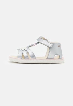 Silverfärgad sandal med öppen tå och utskärningsdesign. Har en kardborreband och detaljer i vitt moln. Texturerad sula med rosa accenter.