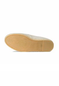 Zool van een beige espadrille-schoen met een gegolfde rubberen ondergrond en een gevlochten juten tussenzool op een witte achtergrond.