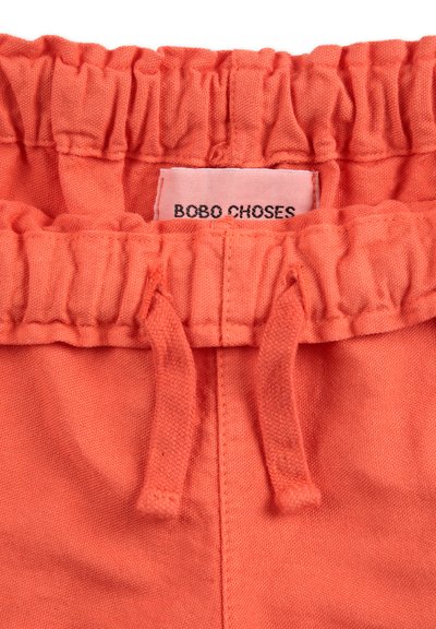 Korallenfarbene Shorts mit elastischem Bund und gerafftem Detail, ausgestattet mit einem Kordelzug und einem Stoffetikett mit der Aufschrift "BOBO CHOSES." Weicher Stoff.