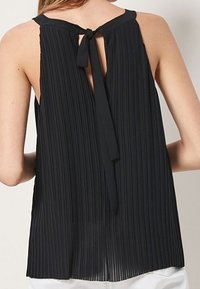 Zwarte geplooide mouwloze top met een striksluiting op de rug, met een vloeiende vorm en een getextureerde stof voor extra visuele interesse.