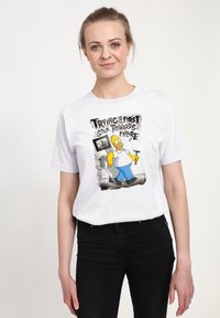 Wit katoenen T-shirt met een kleurrijke cartoonafbeelding van een personage dat een hamer vasthoudt, met tekst tegen een gestructureerde achtergrond.