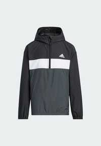 Cazadora con capucha en negro y gris, con media cremallera, que presenta una franja horizontal blanca y un logo de Adidas en el lado izquierdo del pecho. Material ligero.