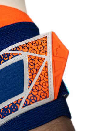 Close-up of blue and orange sports armband with geometric hexagon pattern and white stitching on a person's arm.